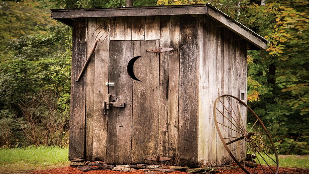 Полумесяц на двери деревянного туалета 
